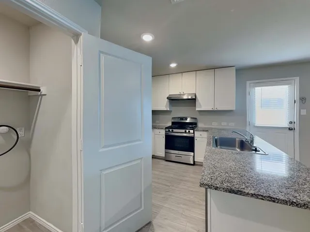 a kitchen with granite countertop a refrigerator sink and stove