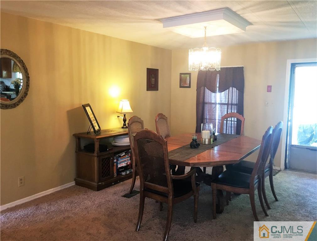 6 Byron Road, Unit 6 North Brunswick, NJ 08902 - Photo 13 of 25 a view of a dining room with furniture and chandelier