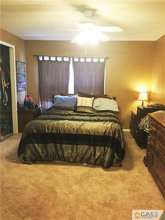 6 Byron Road, Unit 6 North Brunswick, NJ 08902 - Photo 19 of 25 a bed sitting in a bedroom next to a lamp