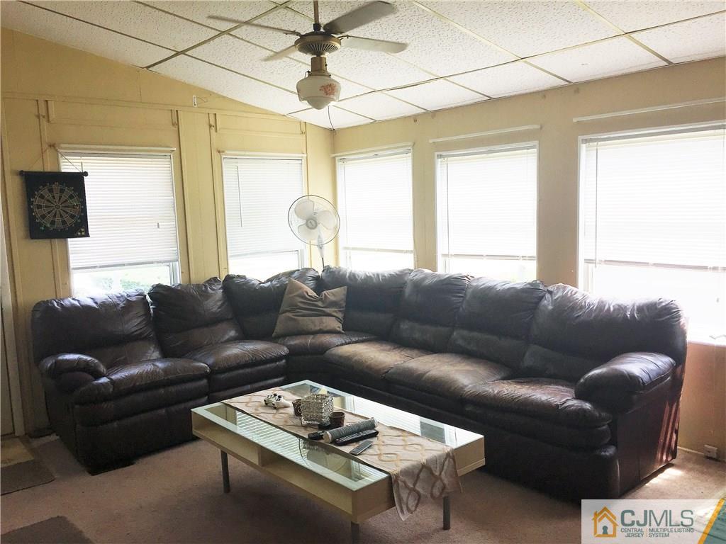 6 Byron Road, Unit 6 North Brunswick, NJ 08902 - Photo 7 of 25 a living room with furniture a flat screen tv and a window