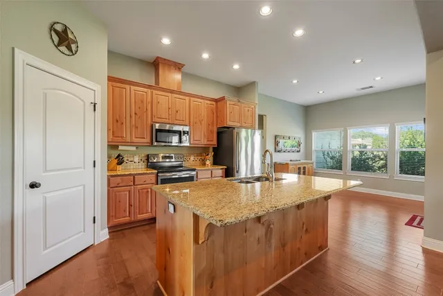 a kitchen with refrigerator cabinets and wooden floor