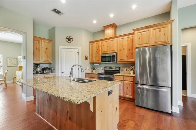 a kitchen with stainless steel appliances granite countertop a refrigerator sink and stove