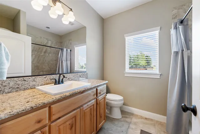 a bathroom with a toilet a sink and mirror