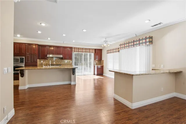 a kitchen with stainless steel appliances granite countertop a refrigerator and a stove top oven