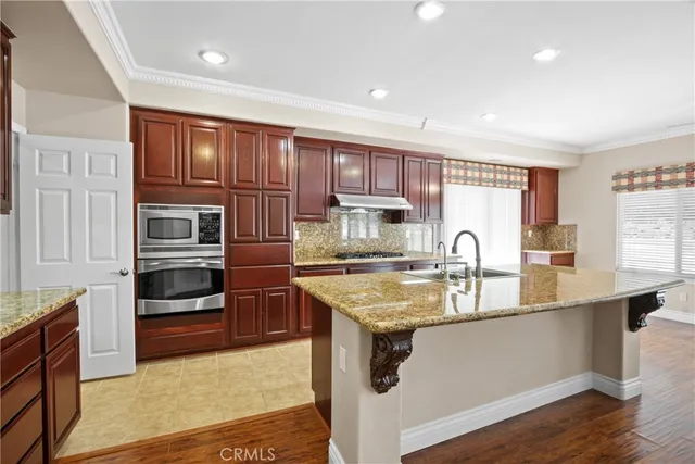 a kitchen with stainless steel appliances granite countertop a sink stove and refrigerator