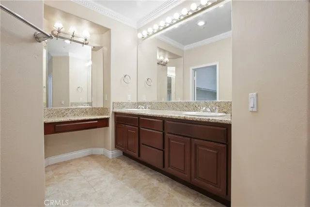 a bathroom with a granite countertop double vanity sink and mirror