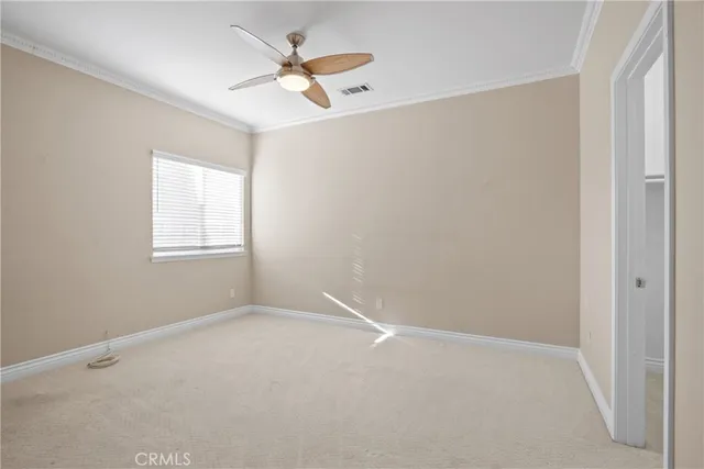 an empty room with a window and a fan