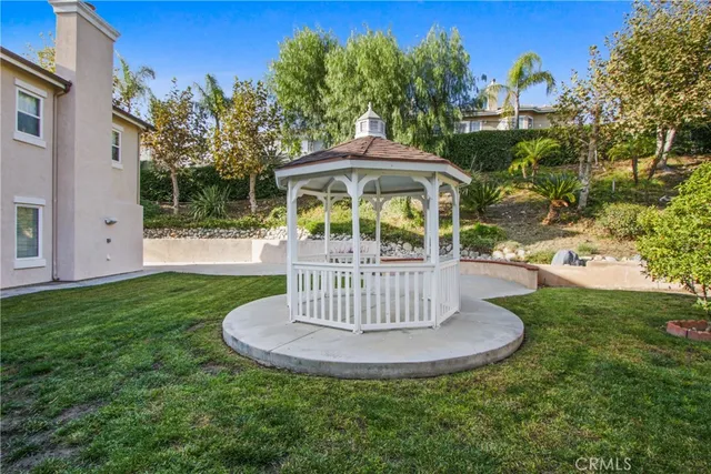 a view of a house with a yard fire pit tables and chairs