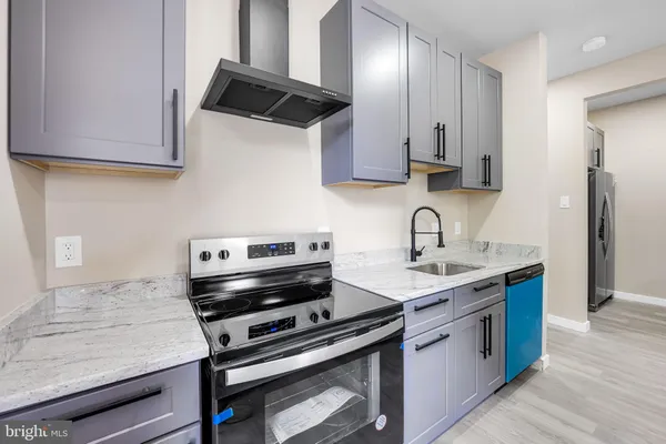 a kitchen with stainless steel appliances granite countertop a sink stove and cabinets