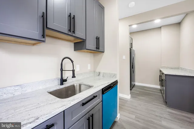 a kitchen with stainless steel appliances granite countertop a sink a stove and a wooden floors