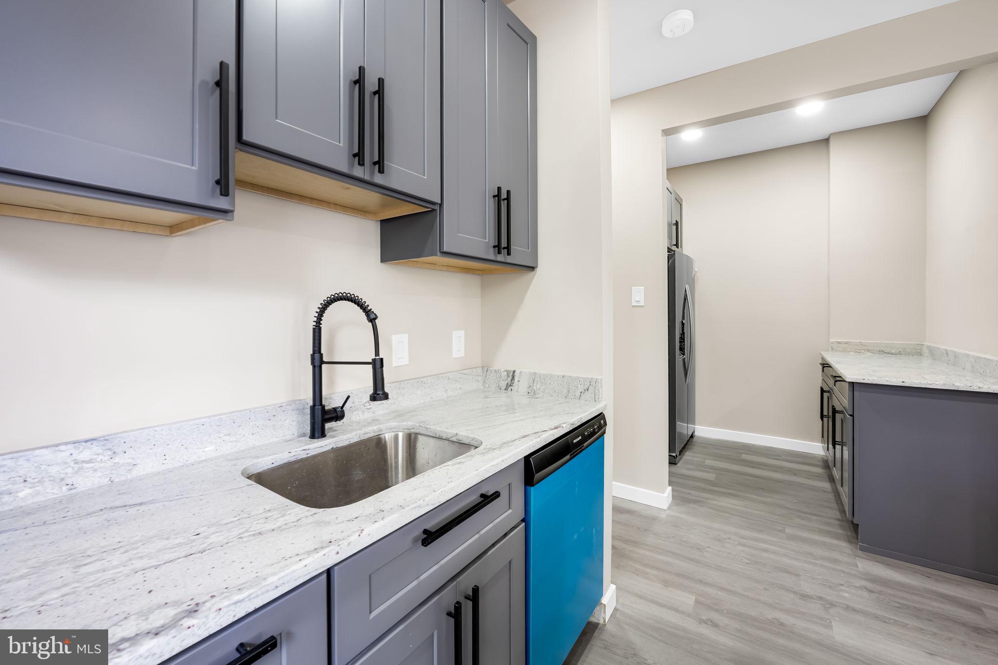 815 East 33rd Street Baltimore, MD 21218 - Photo 12 of 41 a kitchen with stainless steel appliances granite countertop a sink a stove and a wooden floors