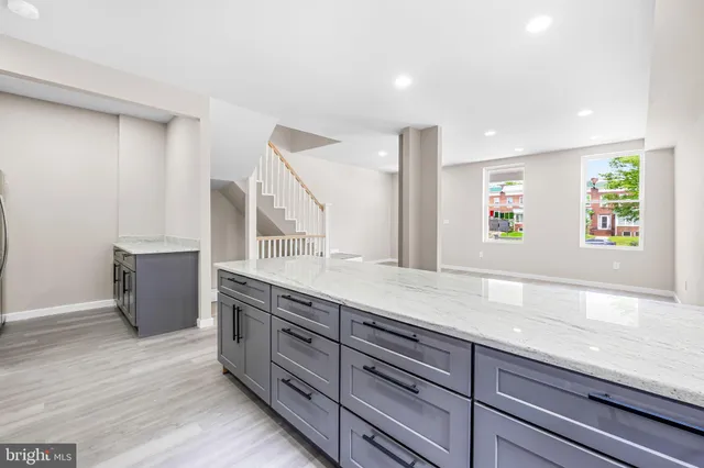 a spacious bathroom with a granite countertop sink and a large mirror