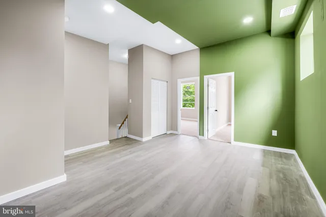 a view of a big room with wooden floor and windows