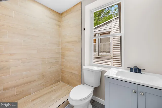 a bathroom with a toilet a sink and a window