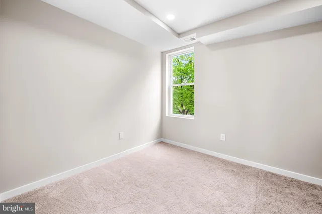 an empty room with window and a ceiling fan