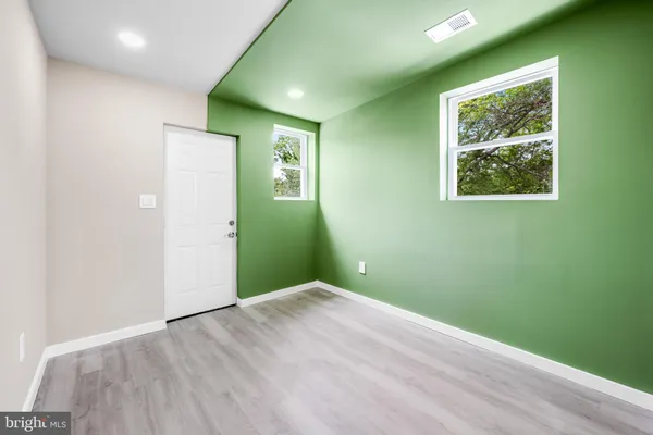an empty room with closet and windows