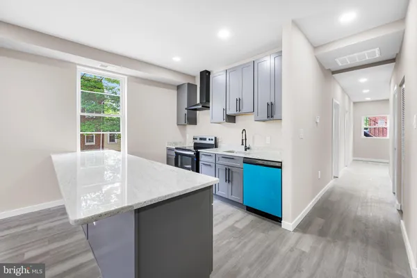 a kitchen with stainless steel appliances kitchen island wooden floors and white cabinets