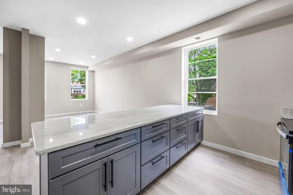 a bathroom with a granite countertop sink a large mirror and a window