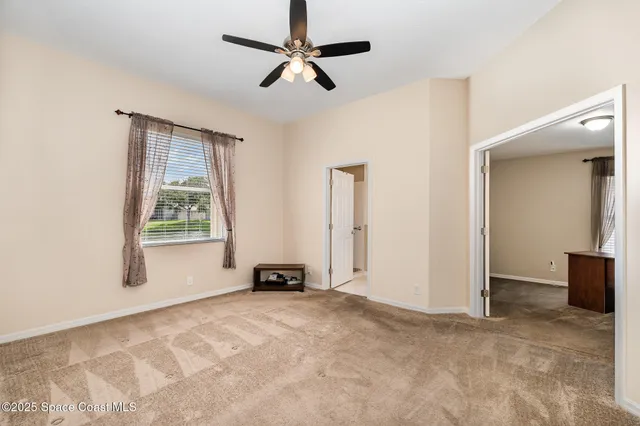a view of a livingroom with a window and a ceiling fan