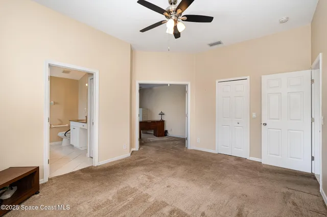 a view of a room with a hanging light and a ceiling fan