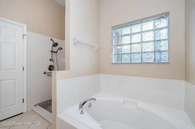 a white bath tub sitting next to a shower