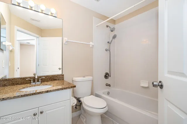 a bathroom with a granite countertop toilet a sink and a bathtub