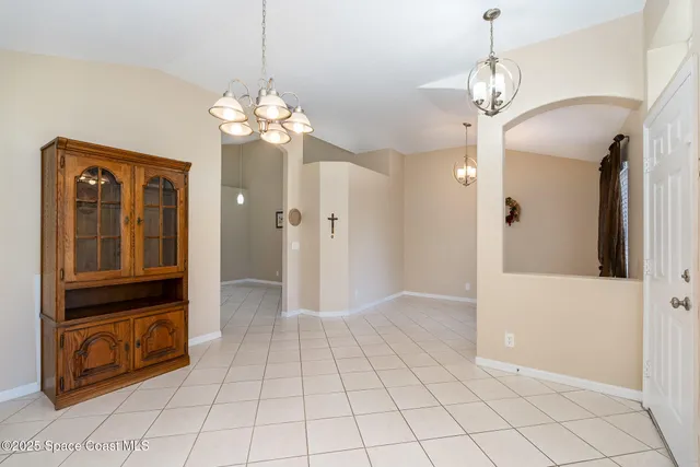 a view of a hallway with wooden floor and a chandelier