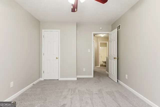 an empty room with chandelier fan