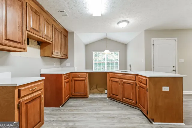 a large kitchen with stainless steel appliances granite countertop a sink and dishwasher a stove with wooden cabinets