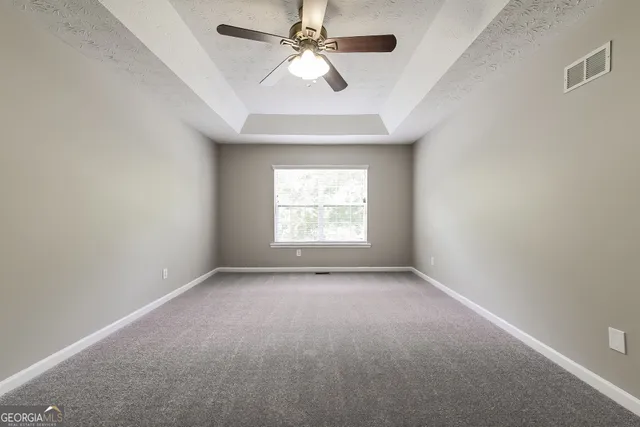 an empty room with a window and a ceiling fan