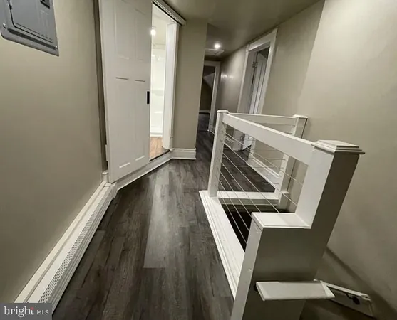 a view of a hallway with wooden floor and stairs