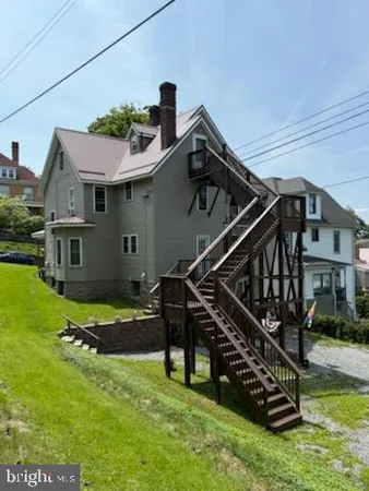 a view of a house with a small yard and wooden fence