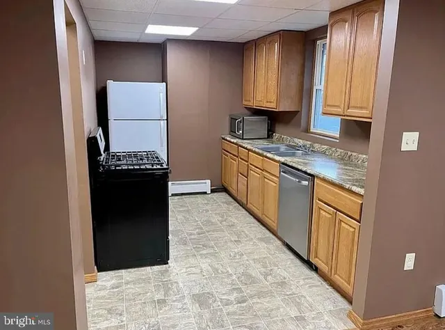 a kitchen with stainless steel appliances granite countertop a stove a sink and a refrigerator