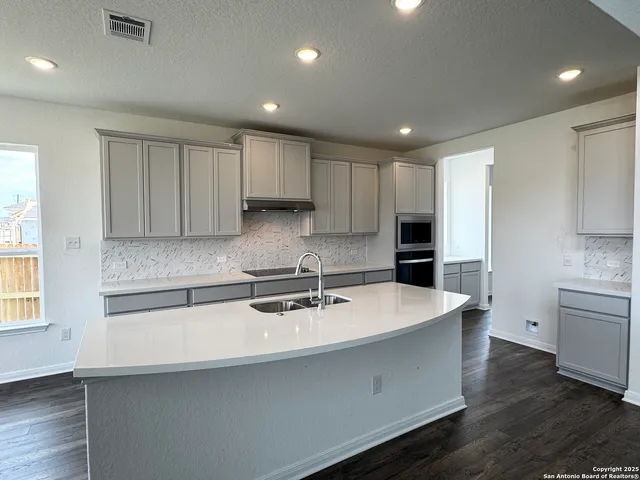 a kitchen with kitchen island a sink stainless steel appliances and cabinets
