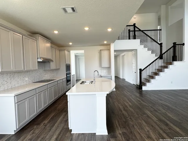 a kitchen with sink cabinets and wooden floor