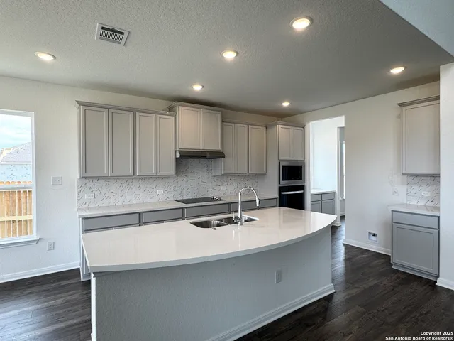 a kitchen with kitchen island a sink stainless steel appliances and cabinets