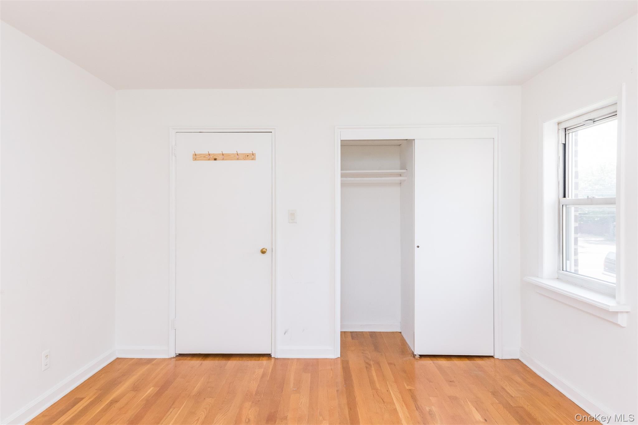 71-07 Ditmars Boulevard Queens, NY 11370 - Photo 8 of 13 a view of an empty room with wooden floor and a window