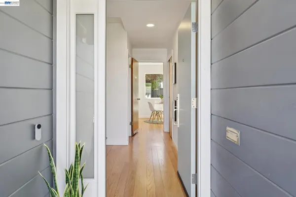 a view of a hallway with wooden flooring and a glass door