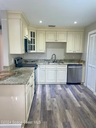 a kitchen with stainless steel appliances granite countertop a sink a stove and cabinets