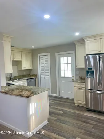 a kitchen with kitchen island granite countertop a sink cabinets and stainless steel appliances