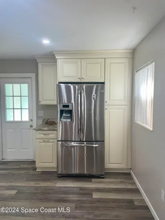 a kitchen with a refrigerator and white cabinets