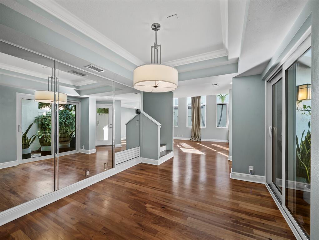 200 Cocoanut Avenue, Unit 7 Sarasota, FL 34236 - Photo 20 of 63 a view of a hallway with wooden floor and a chandelier