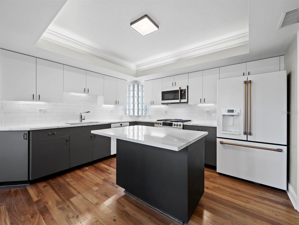 200 Cocoanut Avenue, Unit 7 Sarasota, FL 34236 - Photo 22 of 63 a kitchen with a sink cabinets stainless steel appliances and wooden floor