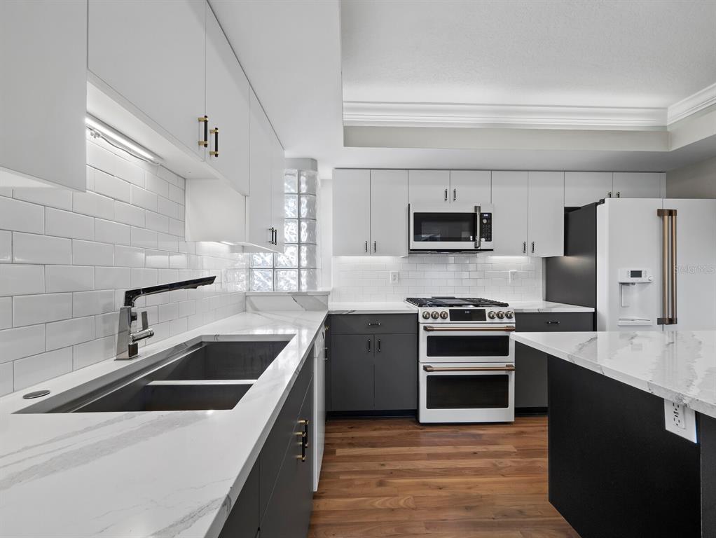 200 Cocoanut Avenue, Unit 7 Sarasota, FL 34236 - Photo 24 of 63 a kitchen with stainless steel appliances granite countertop a stove a sink and a microwave