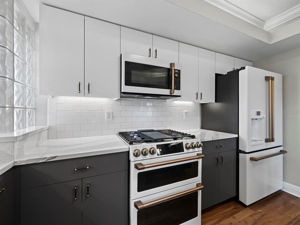 200 Cocoanut Avenue, Unit 7 Sarasota, FL 34236 - Photo 25 of 63 a kitchen with stainless steel appliances a refrigerator stove and microwave