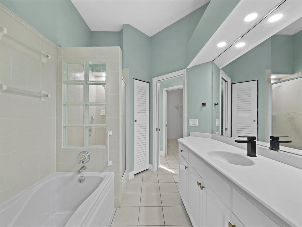 200 Cocoanut Avenue, Unit 7 Sarasota, FL 34236 - Photo 38 of 63 a spacious bathroom with a bathtub shower sink double vanity and a mirror