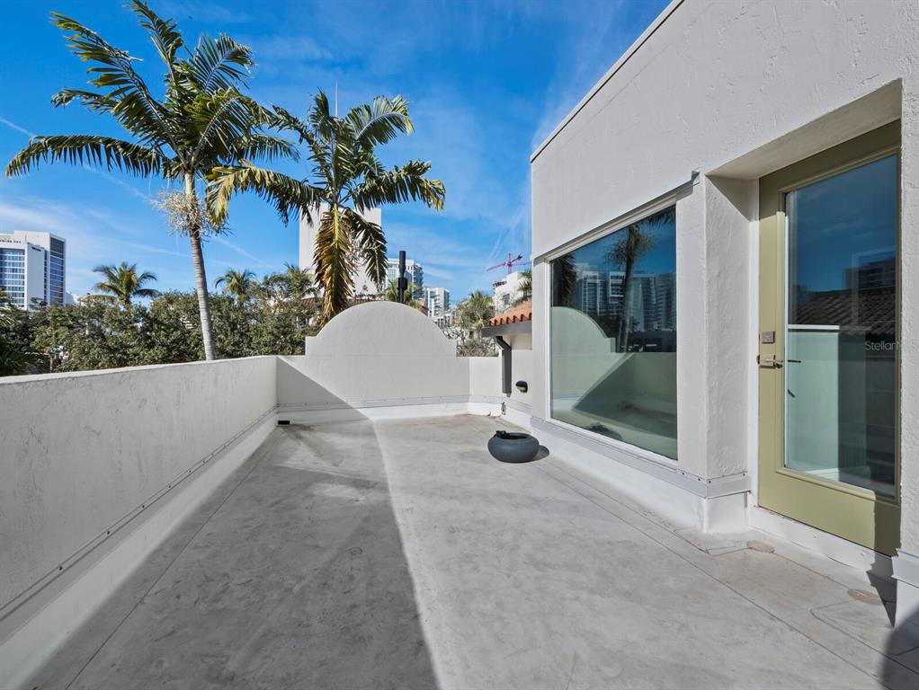 200 Cocoanut Avenue, Unit 7 Sarasota, FL 34236 - Photo 49 of 63 a view of a white house with a yard and potted plants