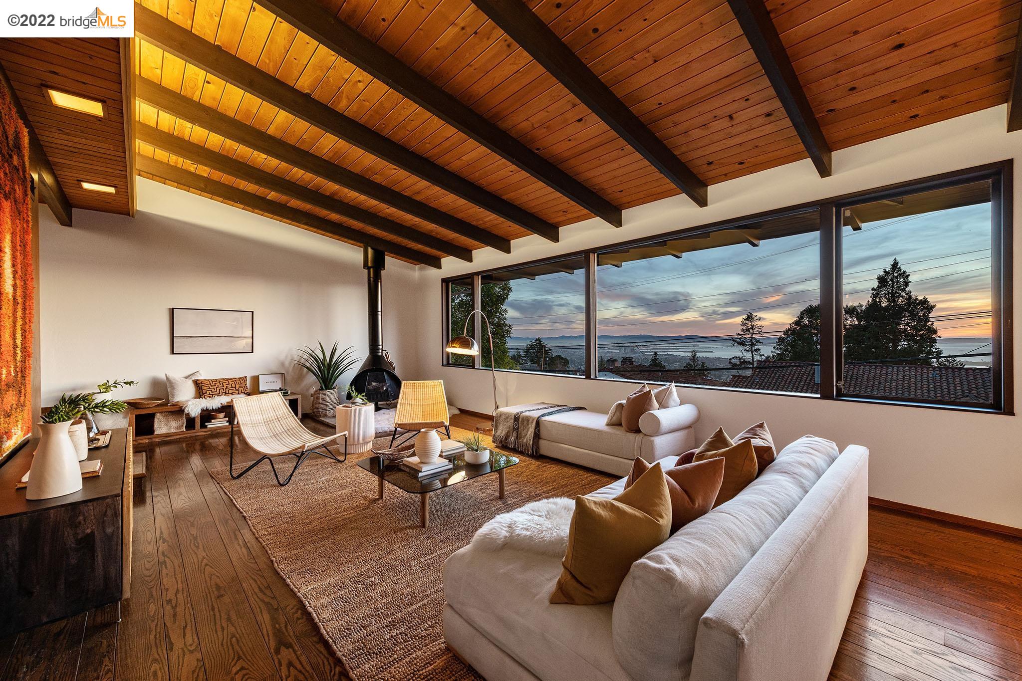 a living room with furniture large window and wooden floor
