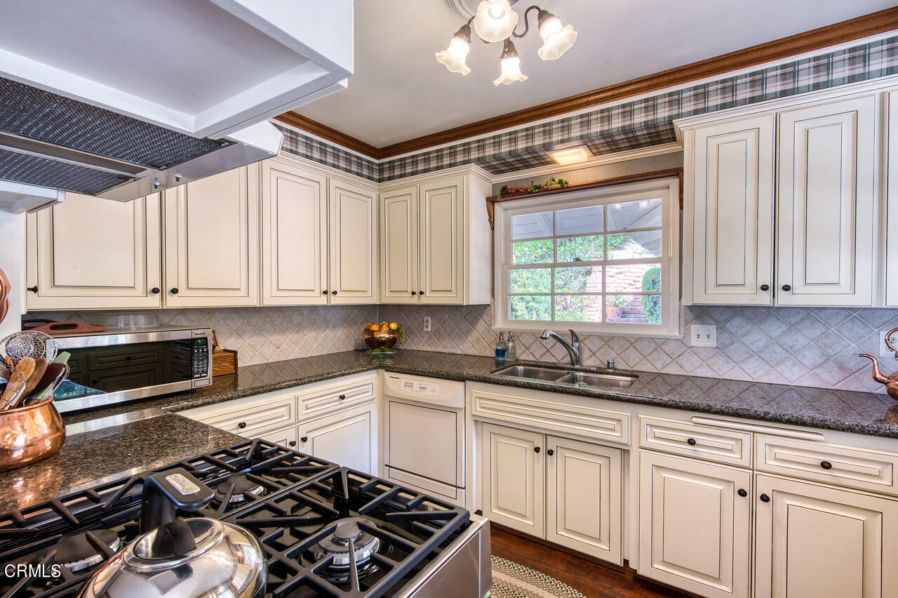 3320 Calvert Road Pasadena, CA 91107 - Photo 13 of 27 a kitchen with granite countertop a sink stainless steel appliances and white cabinets