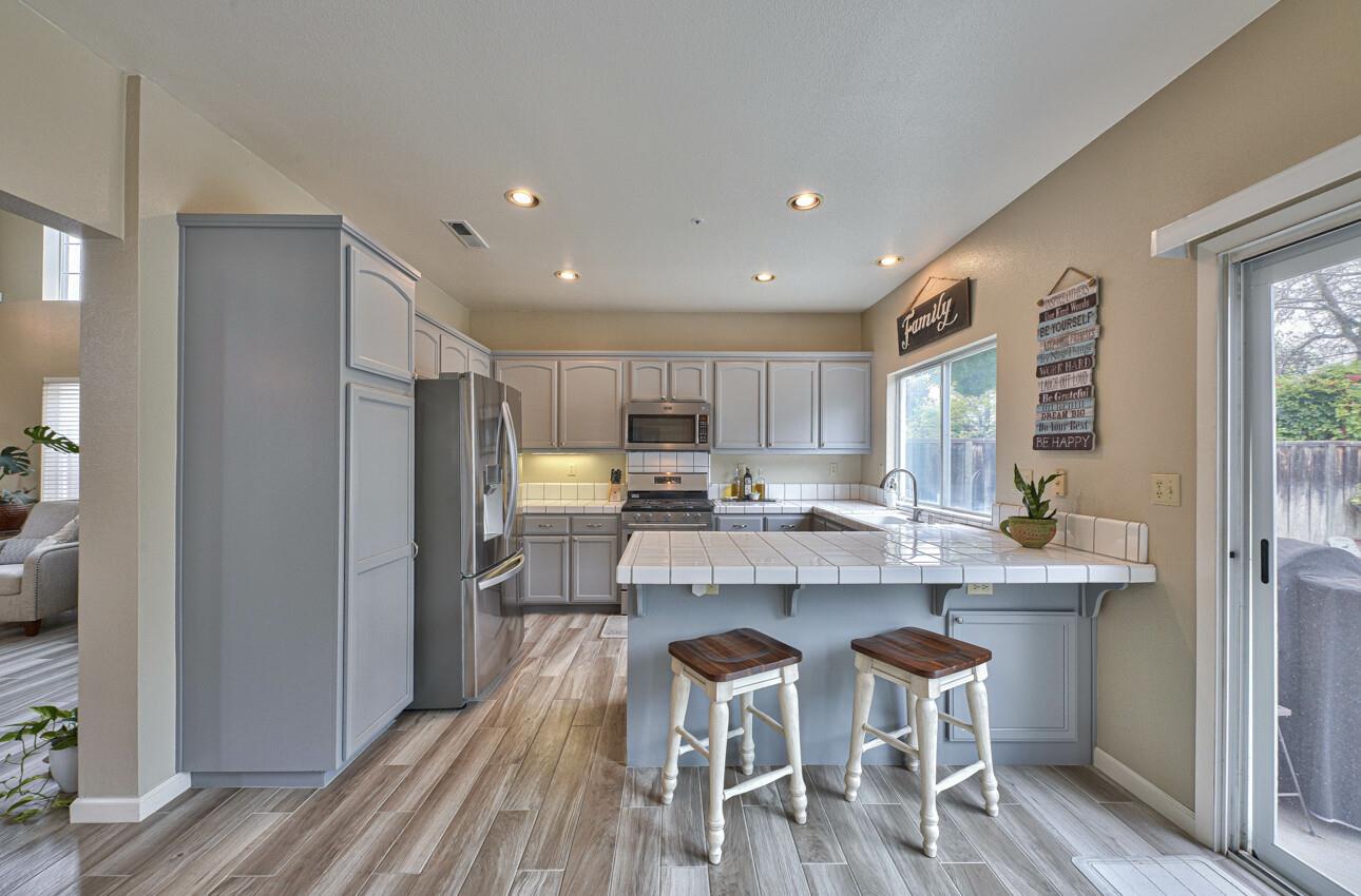 18067 Stonehaven Salinas, CA 93908 - Photo 9 of 33 a kitchen with stainless steel appliances a dining table chairs refrigerator and cabinets
